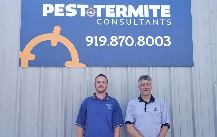two stand up employees of the pest and termite consultand group smiling after being awarded the PTC award