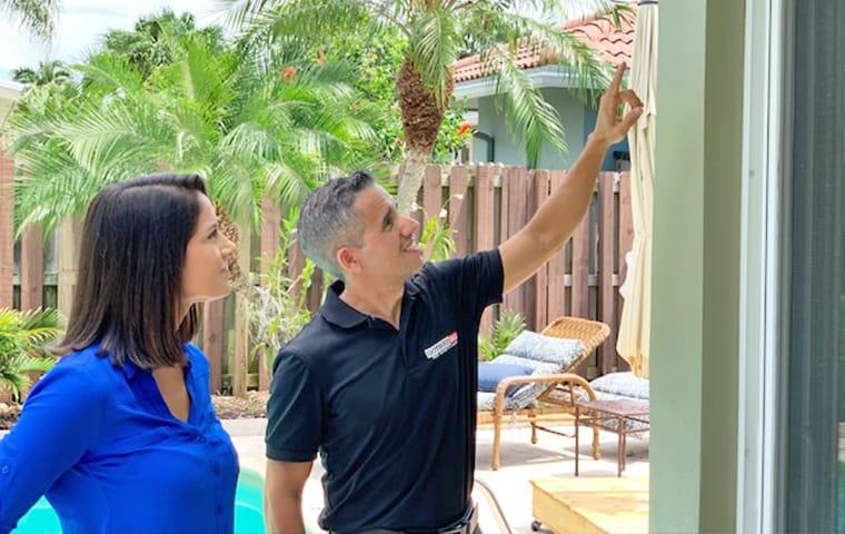 Our KILL365 Plan Covers The Most Common Southeast FL Pests a homeowner and gotbugsikill owner outside of a residential home in boca raton florida