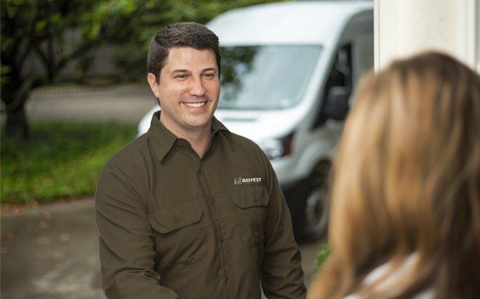 pest control technician greeting a homeowner