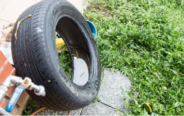 get rid of old tires to help reduce mosquito breeding areas standing water in an old tire in a yard in northern virginia