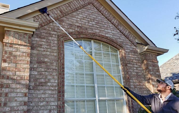 Learn More About Dancan dancan technician cleaning a homes of spider webs
