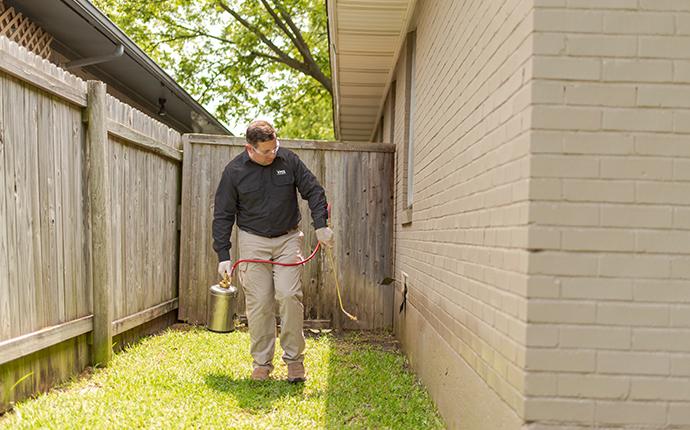 pest control consultants technician treating the perimeter of a dixon illinois home for pests