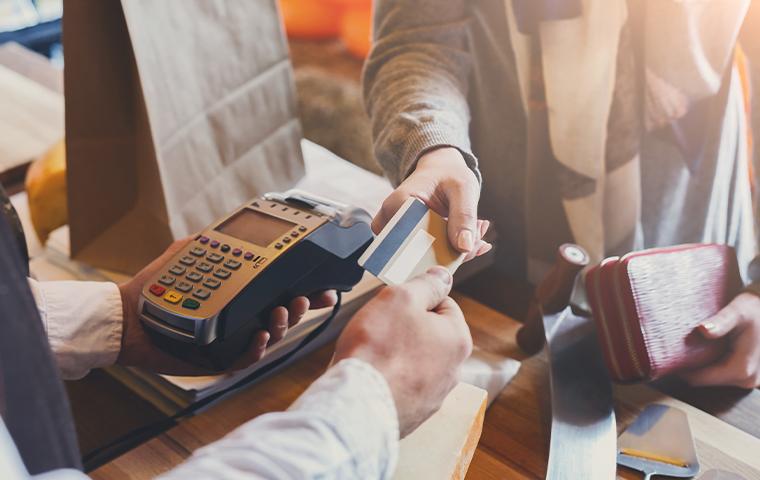 customer handing credit card to store clerk