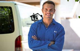 technician smiling in front of van