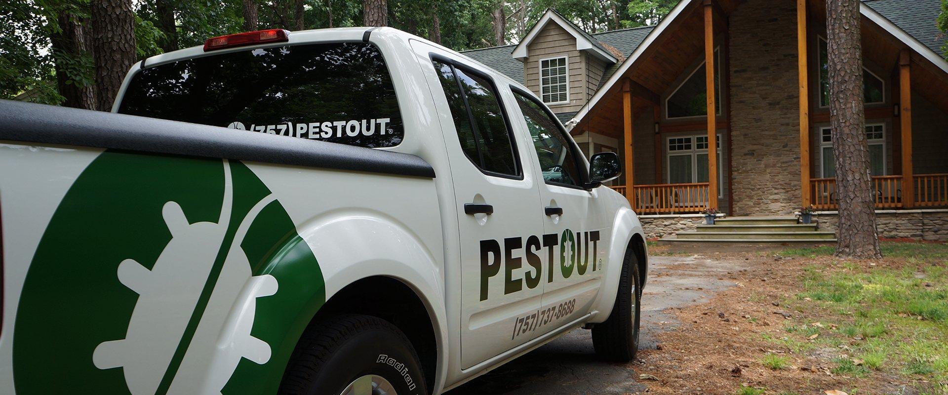 a pest out truck parked in front of a home