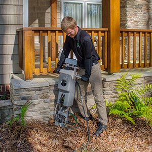 tech servicing exterior of home