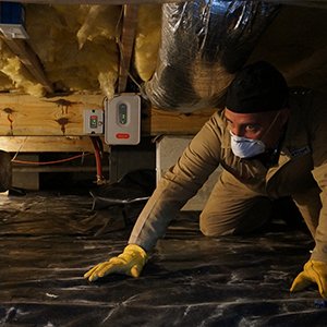 tech inspecting crawlspace under house