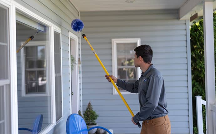 We Provide The Proper Treatments To Protect Your Home a prosite pest control service expert performing dewebbing services outside of a thorp home