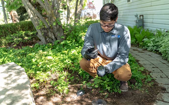 Prosite Experts Prevent Expensive Termite Damage a prosite pest control service expert installing a termite station outside of a home in central washington