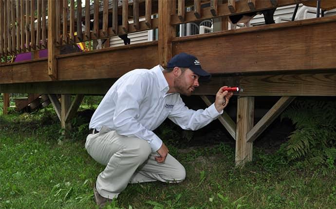 havard pest control technician performing an exterior pest inspection in jacksonville alabama