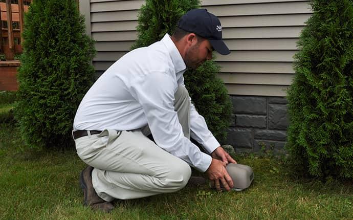 havard pest control technician installing a rodent bait station