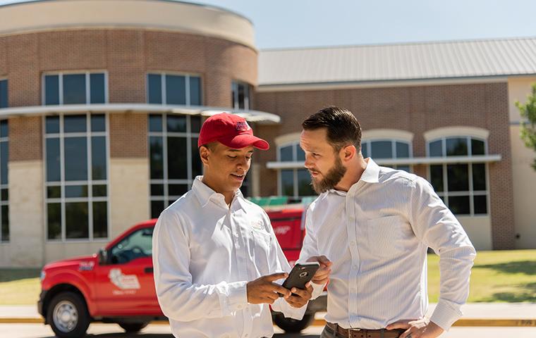 pest control technician and business owner discussing inspection report