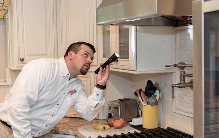 tech inspecting kitchen stove in home