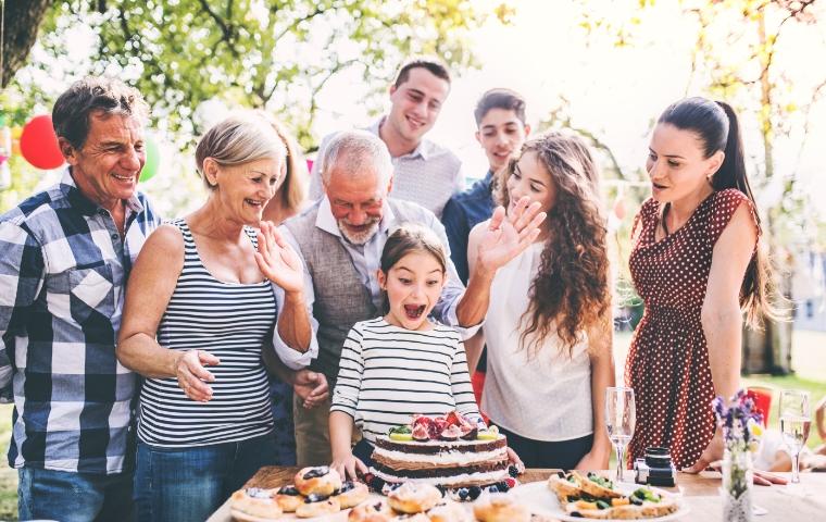 family celebrating outdoor birthday party