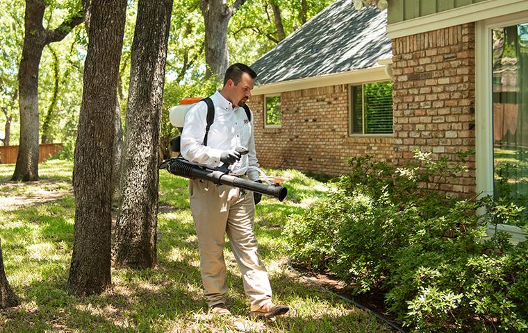 tech treating for mosquitoes using a backpack misting machine