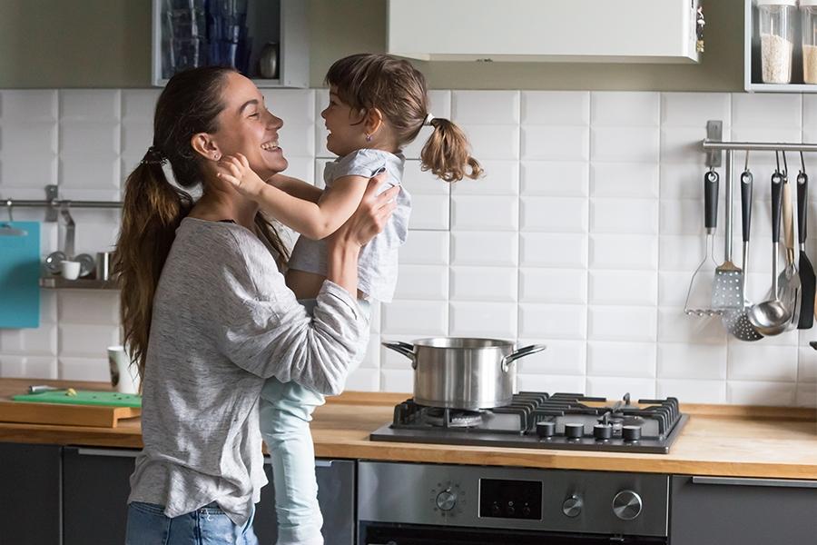 woman and child in front of a kitchen wall