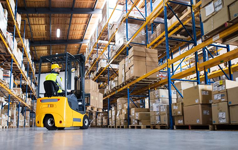 forklift maneuvering boxes in a warehouse setting