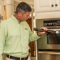technician performing a home inspection in the kitchen