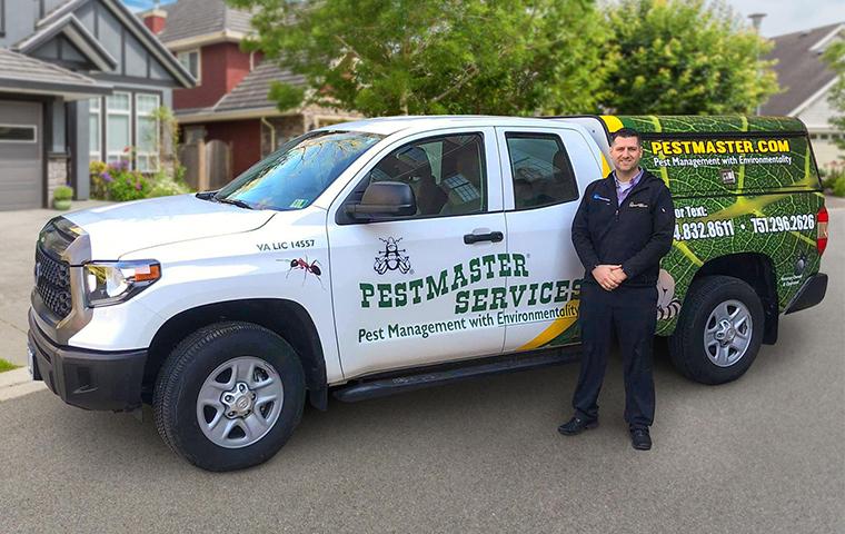 a pest management professional standing by a service vehicle
