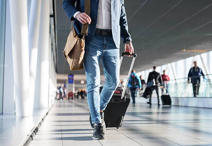 traveling man pulling his suitcase behind him as he walks