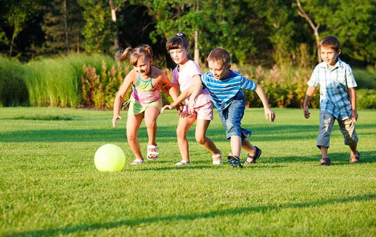 kids kicking a ball around the yard