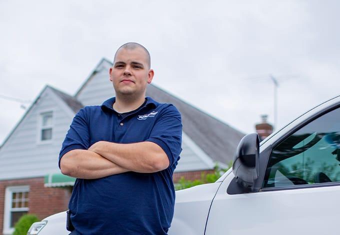 a pest technician standing by his truck