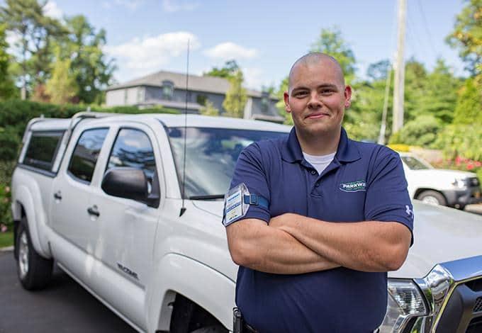 parkway pest services technician standing in front of a white pickup truck