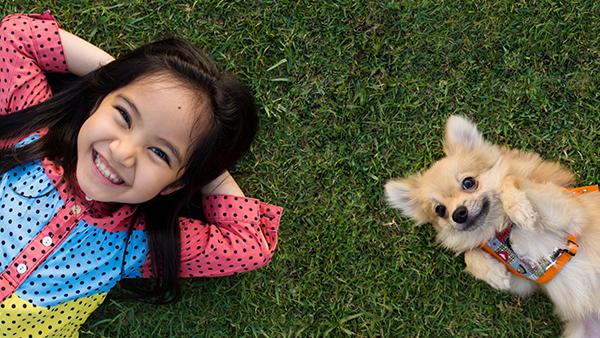 a child and a dog laying in a tick free yard