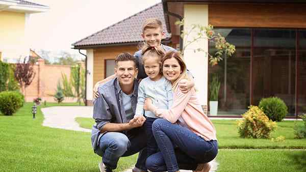 a family posing in front of a home