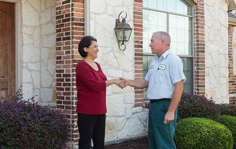 a tech shaking hands with a homeowner