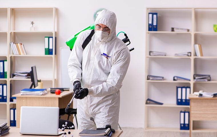 tech sanitizing a classroom