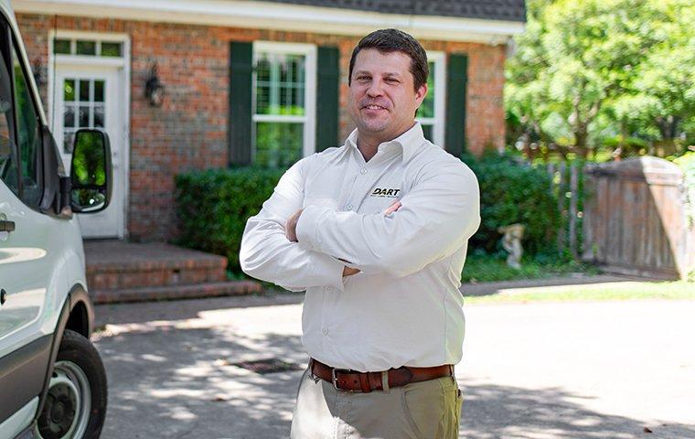 Customer Service Is Our #1 Priority a pest technician standing in front of a customers home in memphis tennessee