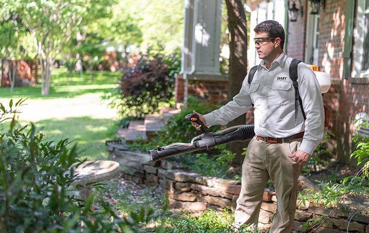 We Offer Mosquito Control, Roach Control & More! a pest technician performing an exterior treatment at a home in memphis tennessee
